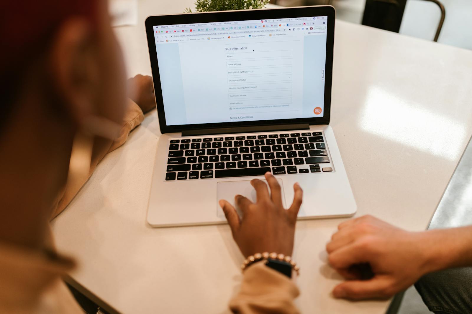 Person füllt Online-Formular am Laptop aus